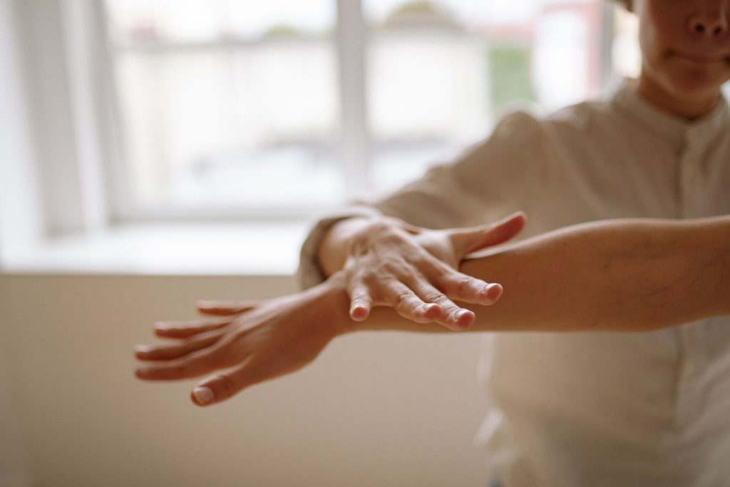 Ergotherapeutin unterstützt eine Patientin bei einer Dehnübung der Hand